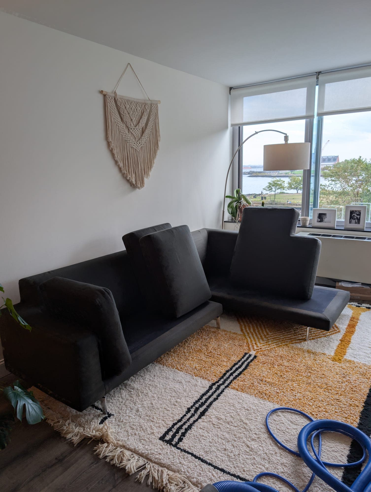Black sectional sofa on patterned area rug with NJ waterfront view