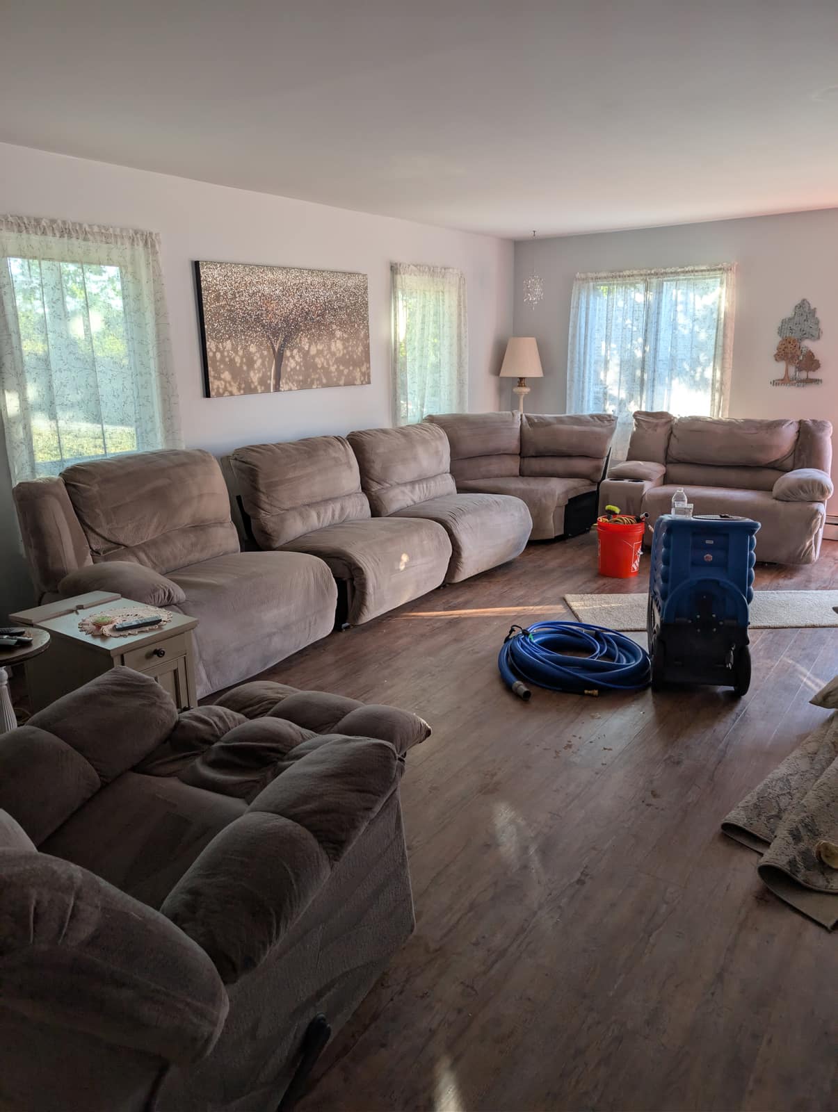 Large brown reclining sectional with an air mover drying the carpet after a multi-room clean