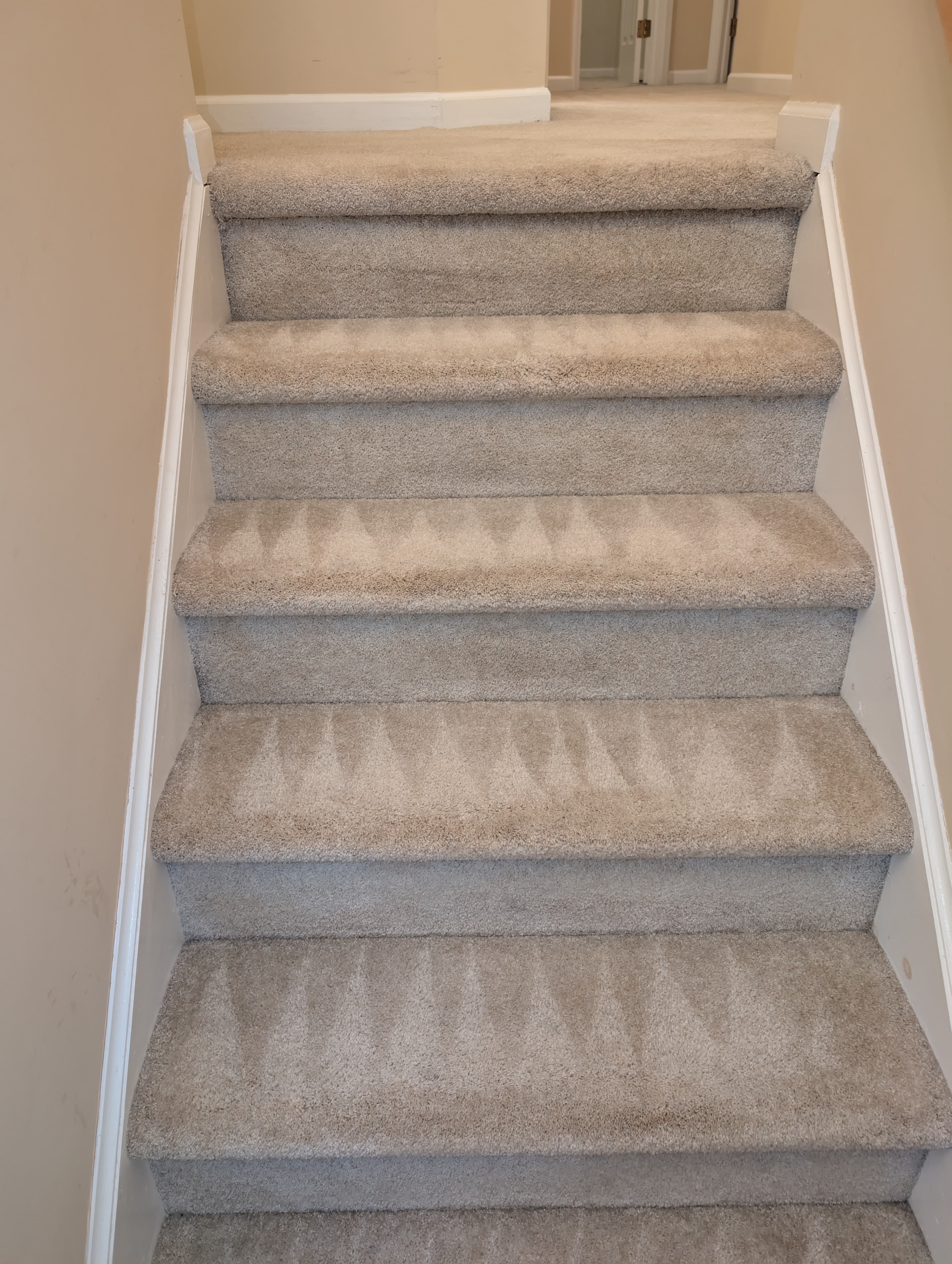 Gray carpeted staircase from above showing every tread